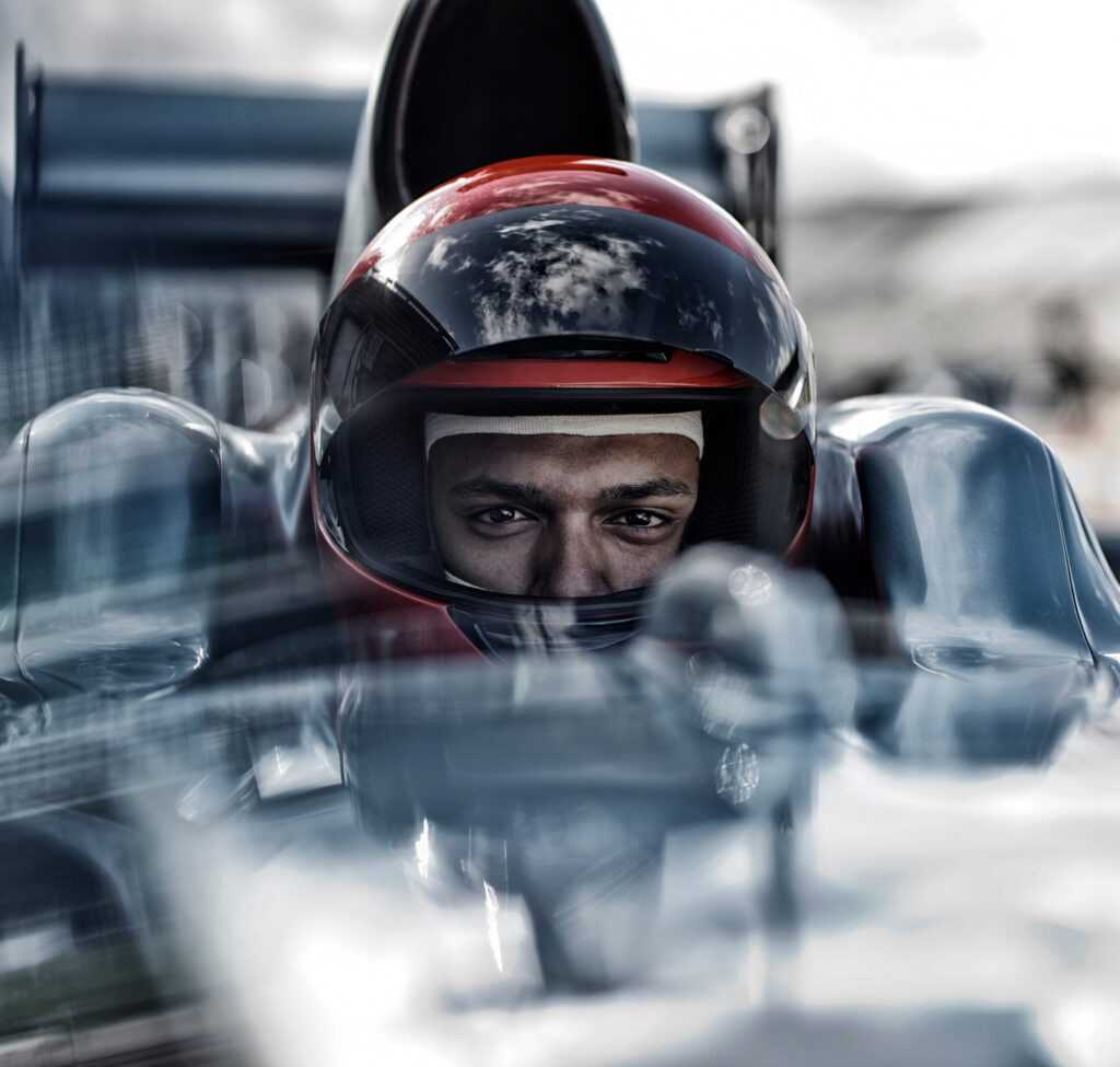 Race car driver wearing red helmet